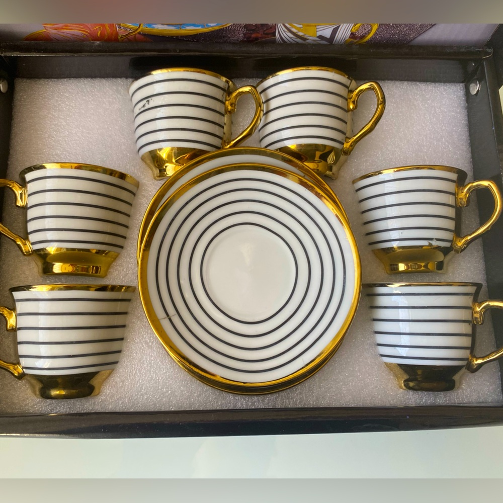 Patterned coffee cups with gold stripes on them.